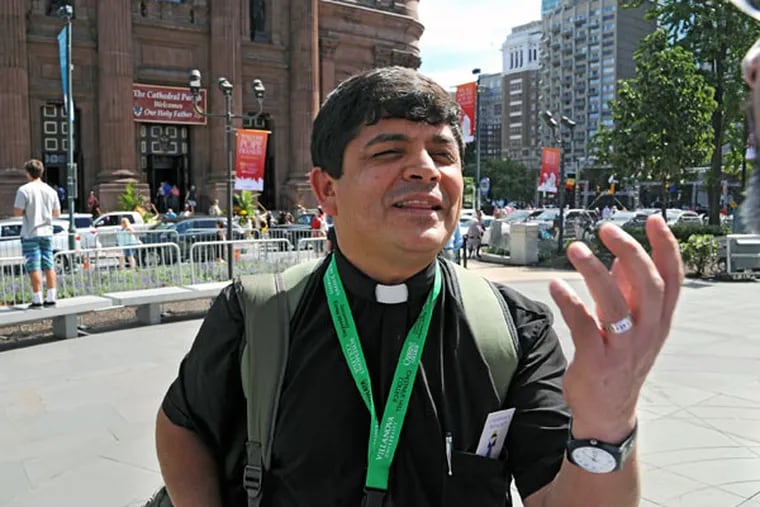 William Villa, a Spanish-speaking priest from Colombia who serves a parish in Jacksonville, Fla., strolled the parkway on Thursday, taking in the scene. He was surprised by the city's architecture and its residents. (CLEM MURRAY/Staff Photographer)