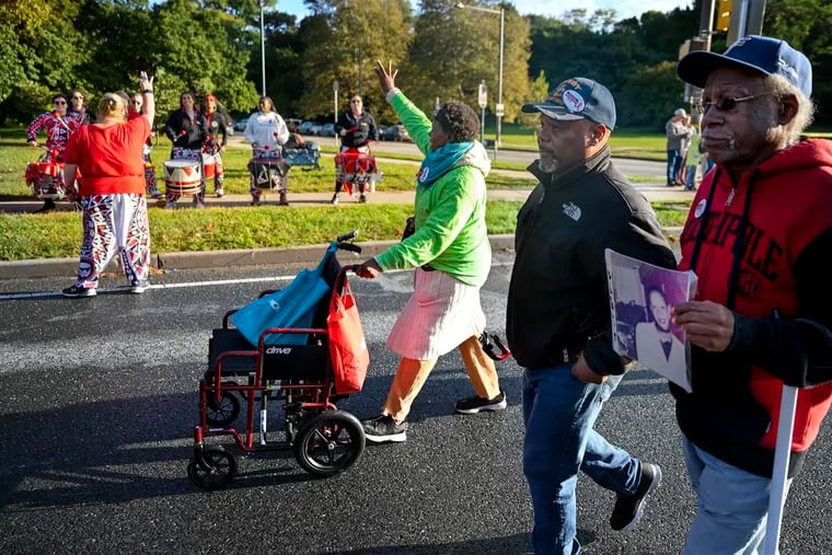 Maurine Taylor Ford waves as she passes the drummers of Batala Philly, who supplied a beat to encourage participants along Kelly Drive during the 37th annual AIDS Walk Sunday morning. Now 51 and from Mount Holly, Ford first devoted herself to AIDS activism as a teenager in New York City.