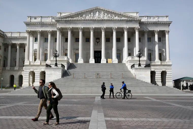 People walk past police officers outside the U.S. Senate steps on Capitol Hill in Washington.