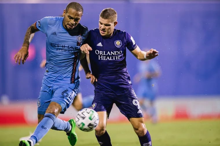 Orlando City's Chris Mueller (right) battles for the ball with New York City FC's Alexander Callens (left) during the second half.