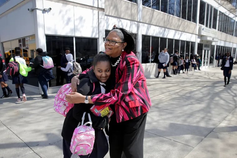 Veronica Joyner, founder and chief administrator, gives a hug to a seventh grader outside Math Sciences and Civics Charter School, the charter she founded in 1999. The school is closing at the end of the year because of Joyner's retirement.