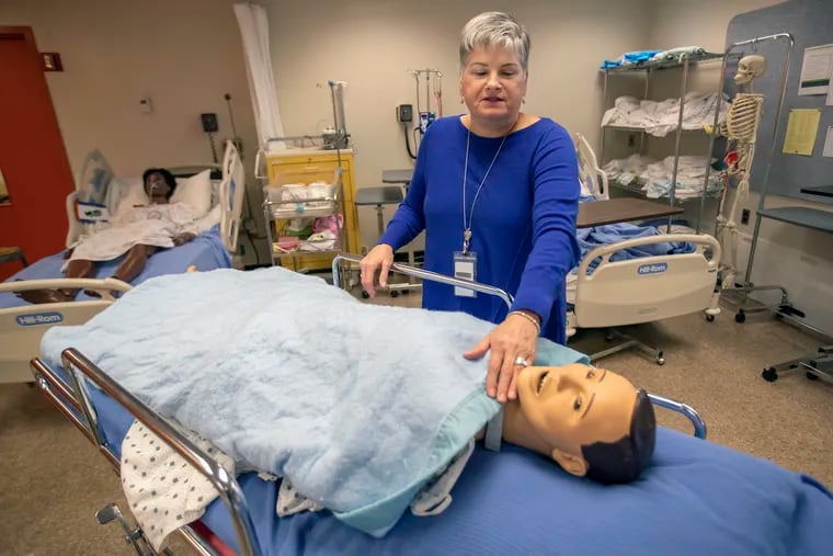 One-year practical nursing program administrator Carol Duell interacts with a low-fidelity mannequin in the skills lab at Eastern Center for Arts and Technology. The skills lab simulates real clinical situations nurses may experience with patients.