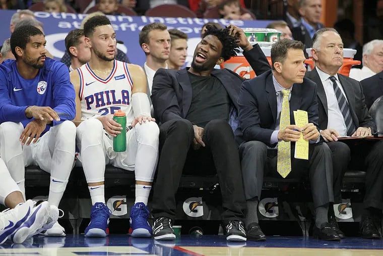 Joel Embiid (center) sits on the bench next to Ben Simmons (2nd from left) during a preseason game against the Grizzlies.