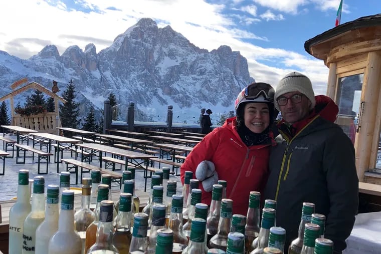 With the jagged spires of the Dolomites as a backdrop, Courtesy of Amy Tara Koch (left), pauses on a guided inn-to-inn ski trip in Italy to try locally brewed grappa in Col dei Baldi.