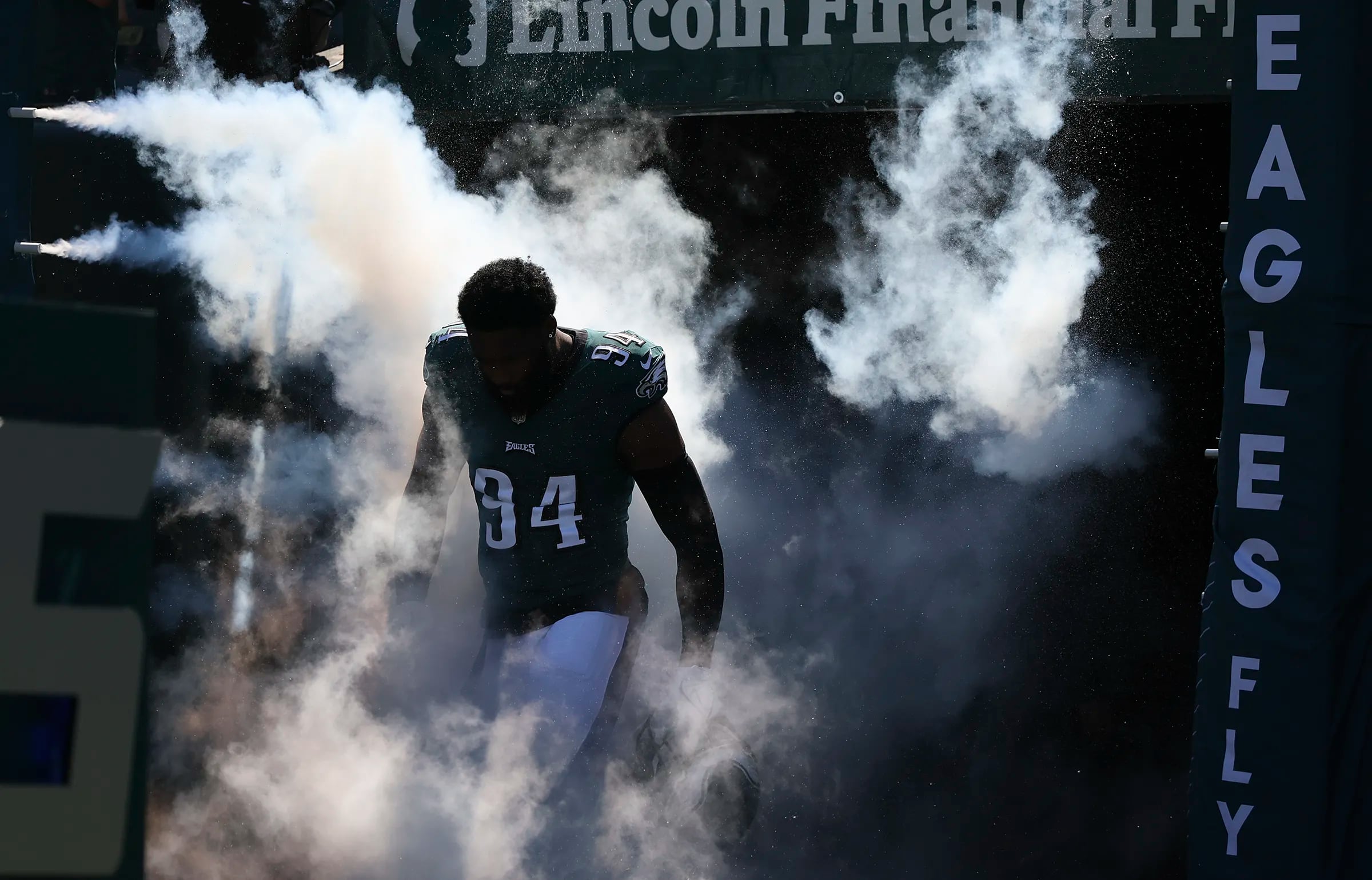 Eagles defensive end Josh Sweat walks in the smoke during player introductions before the Eagles play the Washington Commanders on Sunday, October 1, 2023 in Philadelphia.