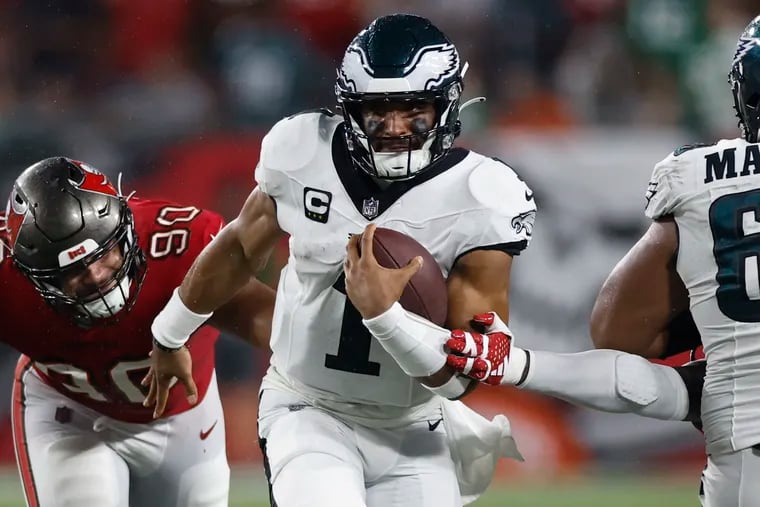 Eagles quarterback Jalen Hurts (1) runs past Buccaneers defensive end Logan Hall late in the first half Monday in Tampa, Fla. Hurts finished with 277 yards on 23-of-37 passing and added 28 rushing yards on 10 carries.