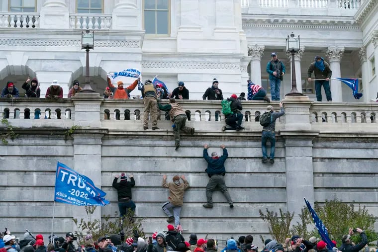 In this Jan. 6, 2021 photo, supporters of then President Donald Trump climb the west wall of the the U.S. Capitol in Washington.