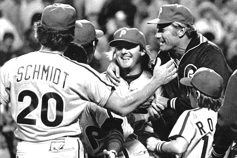 Philles pitcher Tug McGraw is hugged by his manager, Dallas Green (right) and teammates after the Phils won Game 5 of the 1980 World Series. UPI