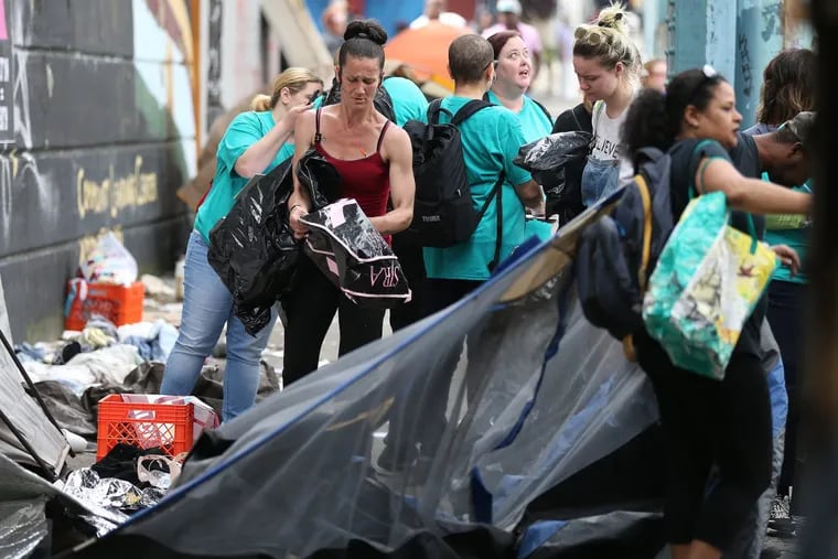 Volunteers help Tiffany Prinski, left, pack up her belongings as police evict people living at the encampment on Kensington Avenue last May.