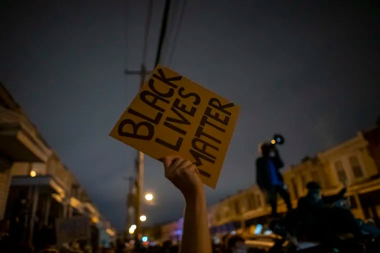 A demonstrator holds a placard reading "Black Lives Matter" during a protest near the location where Walter Wallace Jr. was killed by two police officers on Oct. 27, 2020, in Philadelphia.
