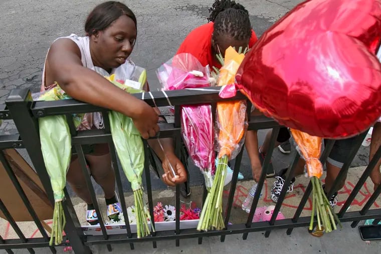 People attend to a memorial at the site of a destroyed Wendy's restaurant Sunday, June 14, 2020, in Atlanta. On Saturday, protestors set fire to the Wendy's where Rayshard Brooks, a black man, was shot and killed by Atlanta police Friday evening following a struggle in the drive-thru line.