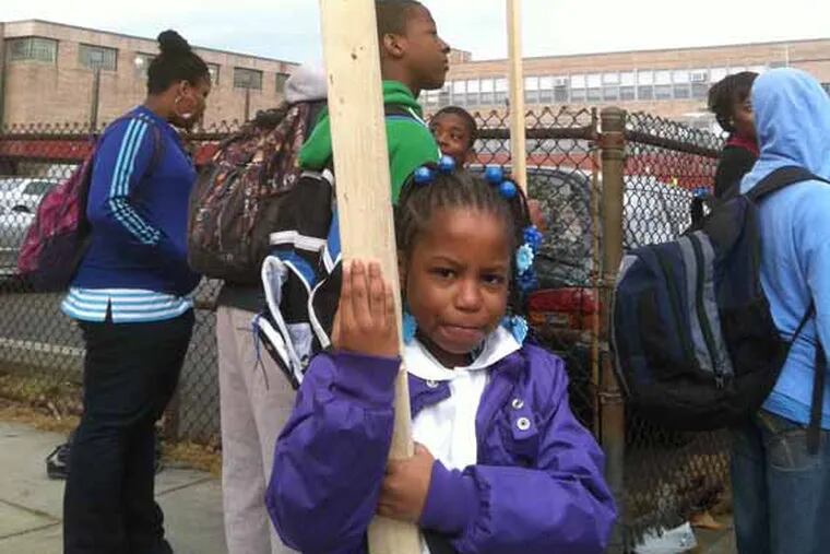 Tionna Travers, 8, protests outside Pastorious School this morning to demand more crossing guards at her school. (Dana DiFilippo / Staff)