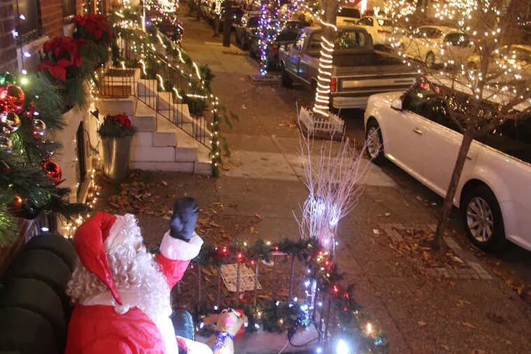 Alex Du puts his whole self into decorating, draped with a necklace of lights. He's with daughter Olivia at their home on South 13th Street. Their waving Santa is a highlight, and Mickey Mouse is prominent: "We love Disney, and we love Christmas," Du says.