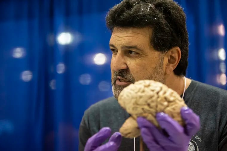 Russell Buono, a researcher at Cooper Medical School of Rowan University who is also known as "Dr. Brain Dude," gives a demonstration on the human brain at the Brain Health Fair inside the Pennsylvania Convention Center in Philadelphia.