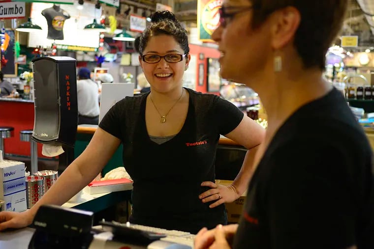 Maria Glover laughs with her mother, Tootsie Iovine-D’Ambrosio, while working the register at Tootsie’s Salad Express in Reading Terminal Market. (BEN MIKESELL/Staff Photographer)