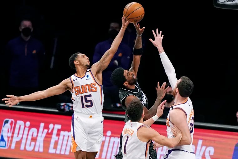 Suns guards Cameron Payne (left) and Devin Booker (center), and forward Frank Kaminsky triple team Brooklyn Nets guard Kyrie Irving.