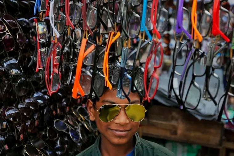 A roadside vendor in Bangladesh wears sunglasses to attract customers to his shop in the capital city of Dhaka. AP