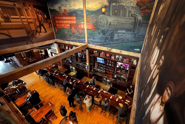 The main bar of the Rusty Rail Brewery Company in Mifflinburg, Union County, under artwork recalling the 19th century rail line that ran through town.