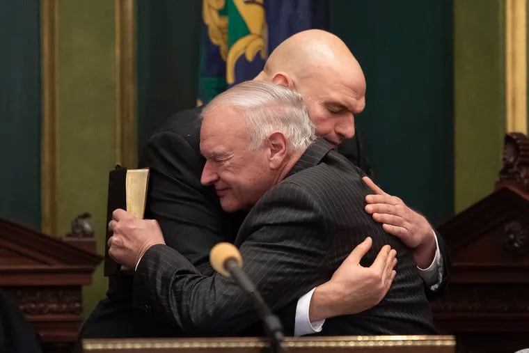 Pa. Lt. Gov. John Fetterman (left) hugs his father, Karl Fetterman, after being sworn in during at the Pennsylvania State Capitol on Tuesday.