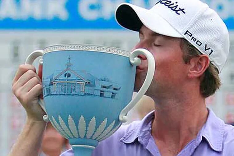 Webb Simpson kisses the trophy after winning the Deutsche Bank Championship in a playoff. (Michael Dwyer/AP)
