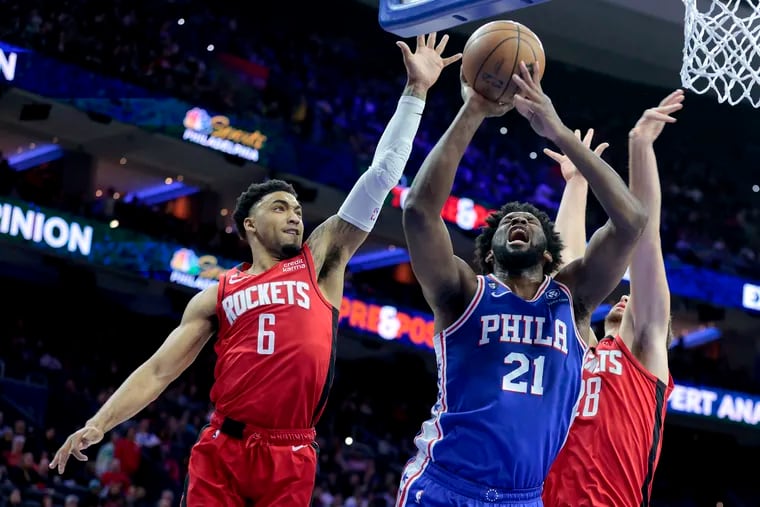The Sixers' Joel Embiid gets fouled as he goes up for a shot between K.J.Martin (left) and Alperen Sengun of the Rockets on Feb. 13.