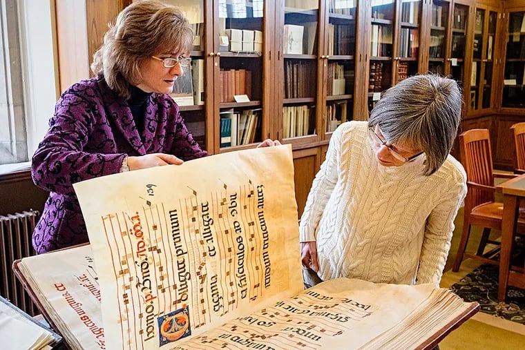 At Lehigh University's Linderman Library, Lois Fischer Black, curator of special collections , left and Christine Roysdon, director for collections, examine a 15th century manuscript entitled "Antiphon," in Latin, on vellum.