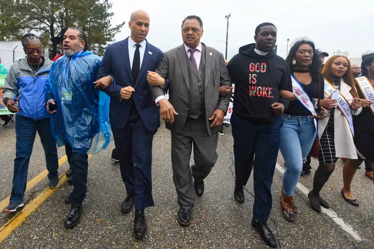 U.S. Sen. Cory Booker, D-N.J., third from left, and the Rev. Jesse Jackson march to cross the Edmund Pettus Bridge Sunday, March 3, 2019, during the Bloody Sunday commemoration in Selma, Ala.  The infamous “Bloody Sunday” on March 7, 1965, galvanized support for the passage of the Voting Rights Act that year. (AP Photo/Julie Bennett)