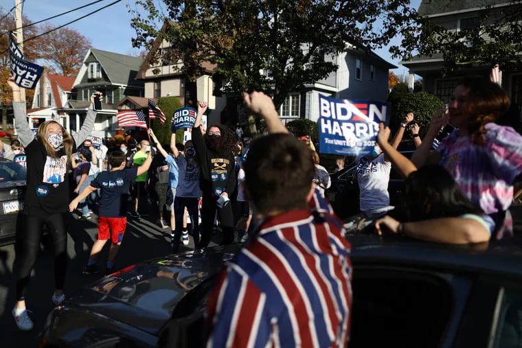 Supporters of President-elect Joe Biden dance alongside passing cars Saturday as they celebrate his victory in front of Biden’s childhood home in Scranton, Pa.