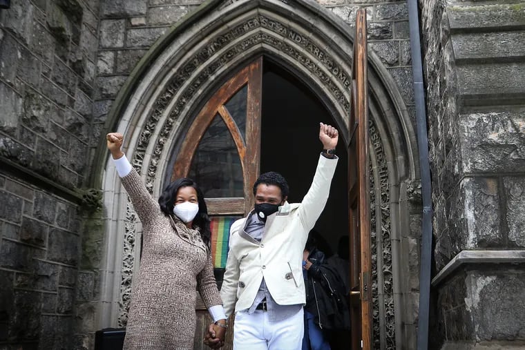 Oneita Thompson and her husband, Clive, raise their arms in victory as they exit the Tabernacle United Church in Philadelphia.