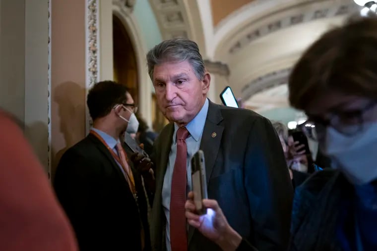 Sen. Joe Manchin, shown making his way through a crowd of reporters at the Capitol in Washington on Tuesday.