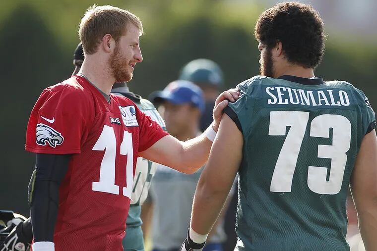 Rookies Carson Wentz and Isaac Seumalo chat before practice earlier this week. CHARLES FOX / Staff Photographer