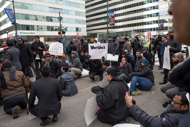Taxicab and Uber Black drivers sit in the middle of 15th Street after parking their cars in front of City Hall and creating gridlock throughout Center City on Thursday afternoon. The drivers were demanding better regulation of UberX and Lyft's operation within the city.
