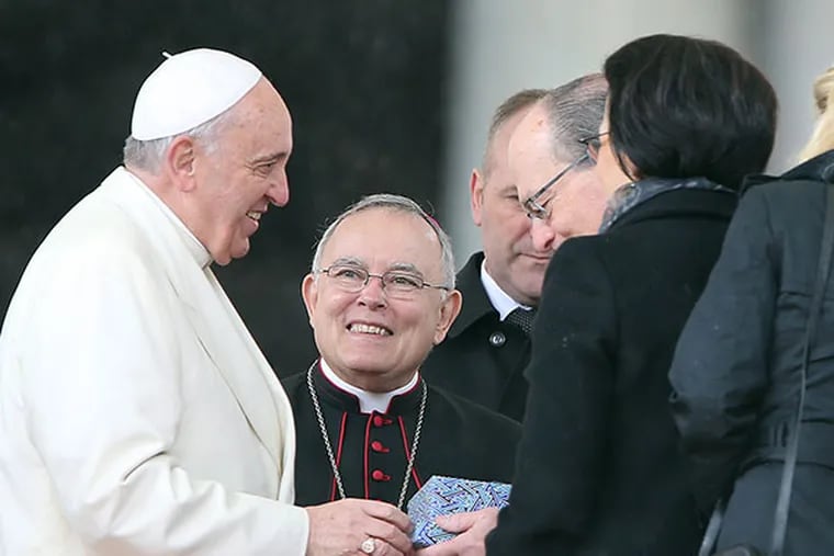 Archbishop Charles Chaput, center, watches as Pope Francis, left, greets members of the Philadelphia delegation during the Papal Audience in St. Peter's Square on March 26, 2014.  ( DAVID MAIALETTI / Staff Photographer )