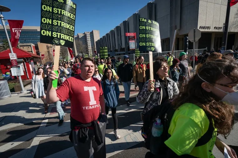 Undergrad Zack Peters (left) walks with others during a protest at Temple University on Wednesday, Feb. 15, 2023, in Philadelphia, in support of the teaching assistants and research assistants, some of whom are on strike.