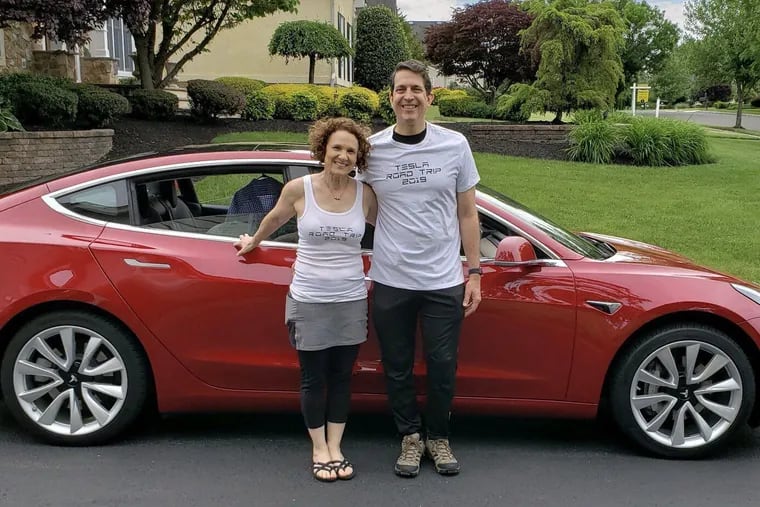 Vivianna, left, and her husband, Peter, right, in front of one of their two Teslas at their Moorestown, Burlington County, N.J. home.