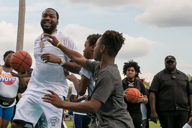 Meek Mill, center, plays basketball on the refurbished and repainted basketball court at East Fairmount Park in the Strawberry Mansion neighborhood of Philadelphia where he grew up on Saturday, Aug. 17, 2019. Mill hosted the Legacy Courts Block Party in conjunction with PUMA, Philadelphia Parks & Rec, Mural Arts Philly and the Strawberry Mansion Community Development Corporation.