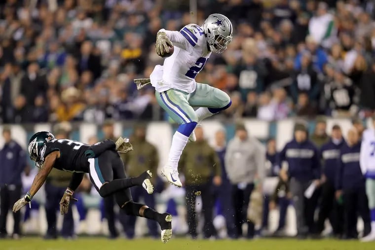 Eagles Tre Sullivan, left, misses a tackle as the Cowboys Ezekiel Elliott, right, leaps over him during the 2nd quarter. Eagles play the Dallas Cowboys at Lincoln Financial Field in Philadelphia, PA on November 11, 2018. DAVID MAIALETTI / Staff Photographer