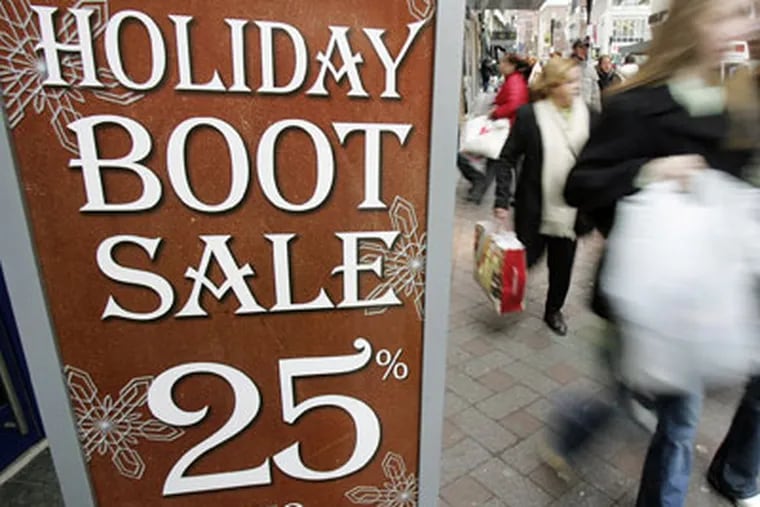 Last-minute shoppers walk past a sale sign in downtown Boston Signs like these upset some Christians, who feel Christmas is being erased from the holiday season. (AP Photo / Michael Dwyer)