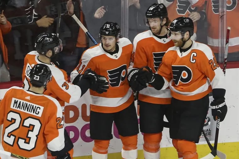 Travis Konecny, center, celebrates with his Flyers teammate after his second goal of the game against Rangers on Thursday.