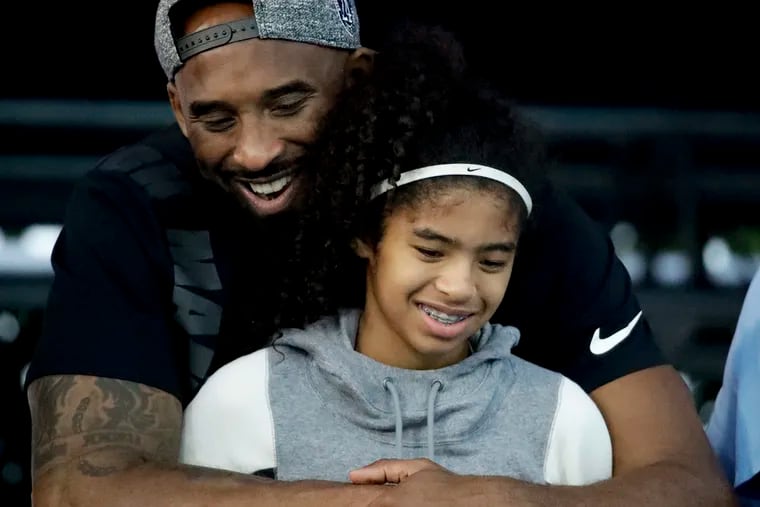 In this July 26, 2018, file photo former Los Angeles Laker Kobe Bryant and his daughter Gianna watch during the U.S. national championships swimming meet in Irvine, Calif.
