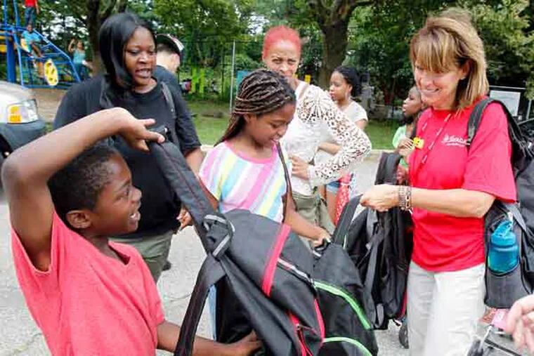 Dymiler Tindell,7 (left) and Damaaya Tindell,10 are getting backpacks from Karen Harhi from St. Christopher's Children's Hospital. Aug.9, 2013( AKIRA SUWA  /  Staff Photographer )