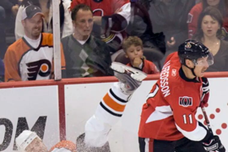 Flyers&#0039; Andrew Alberts lands on his butt as Senators Daniel Alfredsson makes a play.