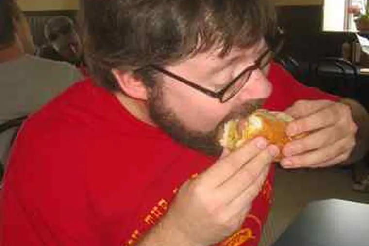 Hawk Krall tucks into a specialty of the house at Moe’s Hot Dog House, 26th and Washington.