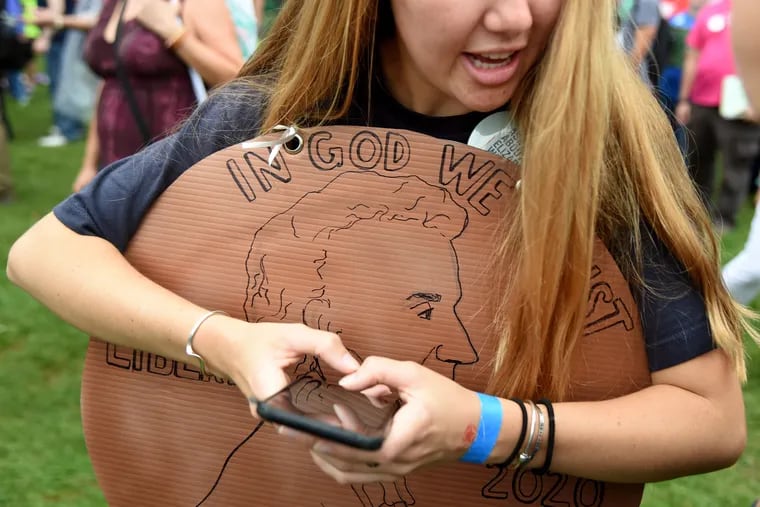 Campaign field organizer Olivia Ellis from Sanford, Fla wears a large penny in honor of the 2-percent wealth tax on ultra-millionaires proposed by Sen. Elizabeth Warren of Massachusetts. Ellis worked voters at the Polk County Steak Fry in Des Moines, Iowa on Sept. 21, 2019.