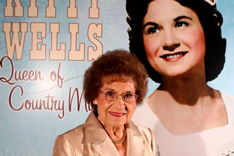 FILE - This Aug. 14, 2008 file photo originally released by the Country Music Hall of Fame and Museum shows music pioneer Kitty Wells at an exhibit honoring her career in Nashville, Tenn.  Wells, the first female superstar of country music, has died at the age of 92. The singer’s family says Wells died at her home Monday after complications from a stroke. Her recording of "It Wasn't God Who Made Honky Tonk Angels" in 1952 was the first No. 1 hit by a woman soloist on the country music charts. Other hits included "Making Believe" and a version of "I Can't Stop Loving You."  (AP Photo/Country Music Hall of Fame and Museum, Donn Jones, file)