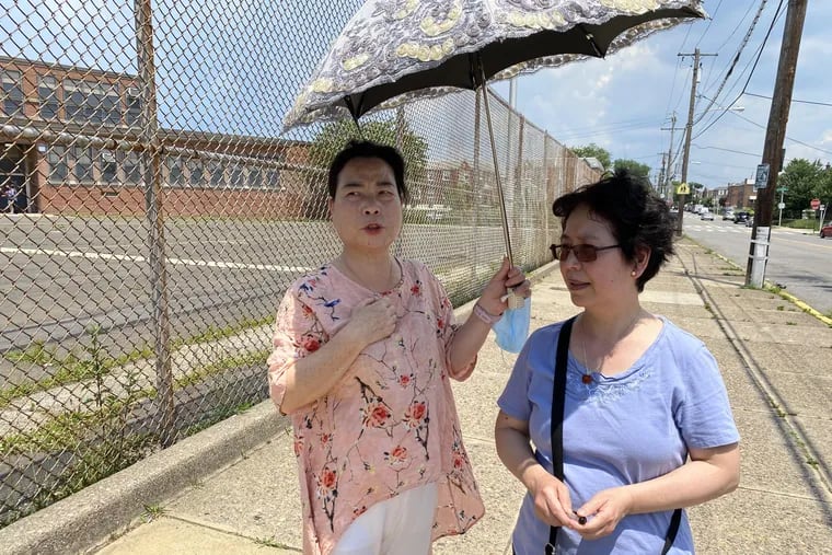 Yue Xian Wu, left, and Mingchu Pearl Huynh, right, president of the Northeast Philadelphia Chinese Association, talk about an attack that occurred last week on Hawthorne Street in Mayfair. Wu's 17-year-old grandson was randomly punched in the head and back by two teens.
