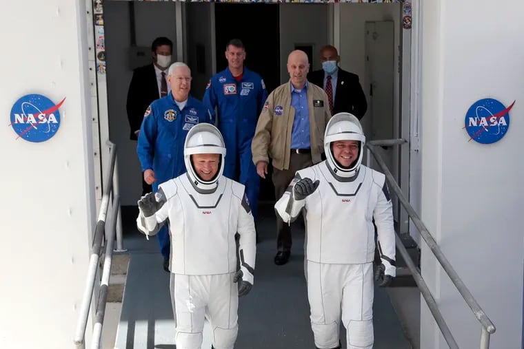 NASA astronauts Douglas Hurley, left, and Robert Behnken walk out of the Neil A. Armstrong Operations and Checkout Building on their way to Pad 39-A, at the Kennedy Space Center in Cape Canaveral, Fla., Saturday, May 30, 2020. The two astronauts will fly on a SpaceX test flight to the International Space Station. For the first time in nearly a decade, astronauts will blast into orbit aboard an American rocket from American soil, a first for a private company. (AP Photo/John Raoux)