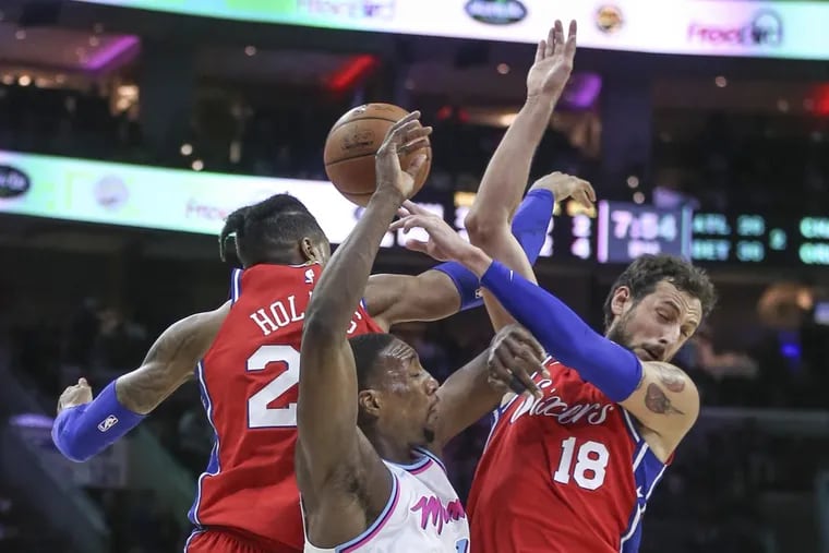 Sixers' Richaun Holmes and Marco Belinelli collide with the Heat's Bam Adebayo during the 2nd quarter at the Wells Fargo Center in Philadelphia, Wednesday, February 14, 2018.