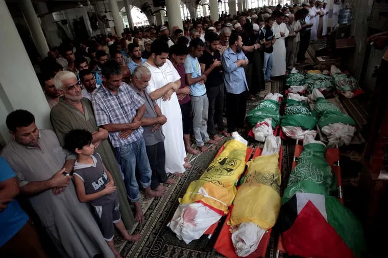 Mourners pray over the bodies of nine Palestinians killed in an early morning Israeli missile strike, at Bilal mosque in the Khan Younis refugee camp in Gaza. The United Nations estimates that 80 percent of the casualties are civilians, many of them children.