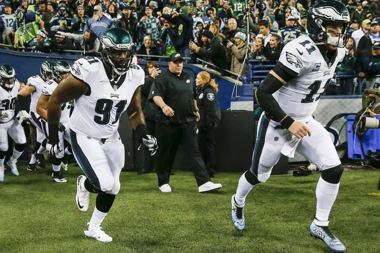 Eagles quarterback Carson Wentz and defensive tackle Fletcher Cox lead their team to the the field against the Seattle Seahawks on Sunday, December 3, 2017 at CenturyLink Field in Seattle. YONG KIM / Staff Photographer